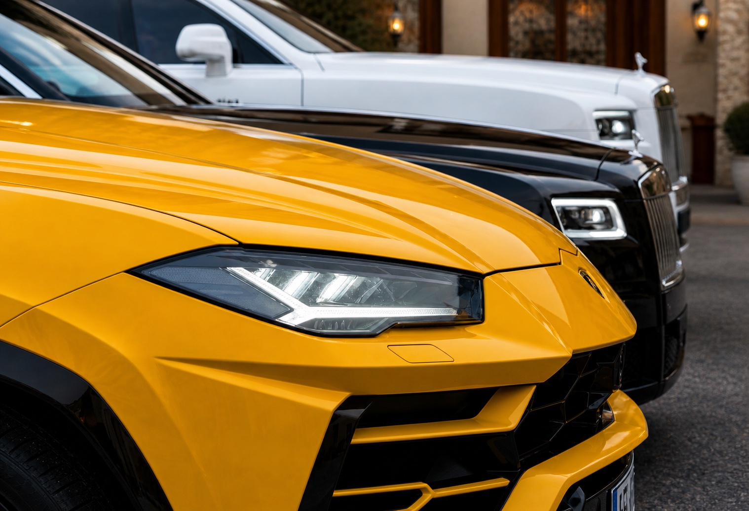 Yellow Lamborghini and Rolls-Royce cars parked outside a hotel